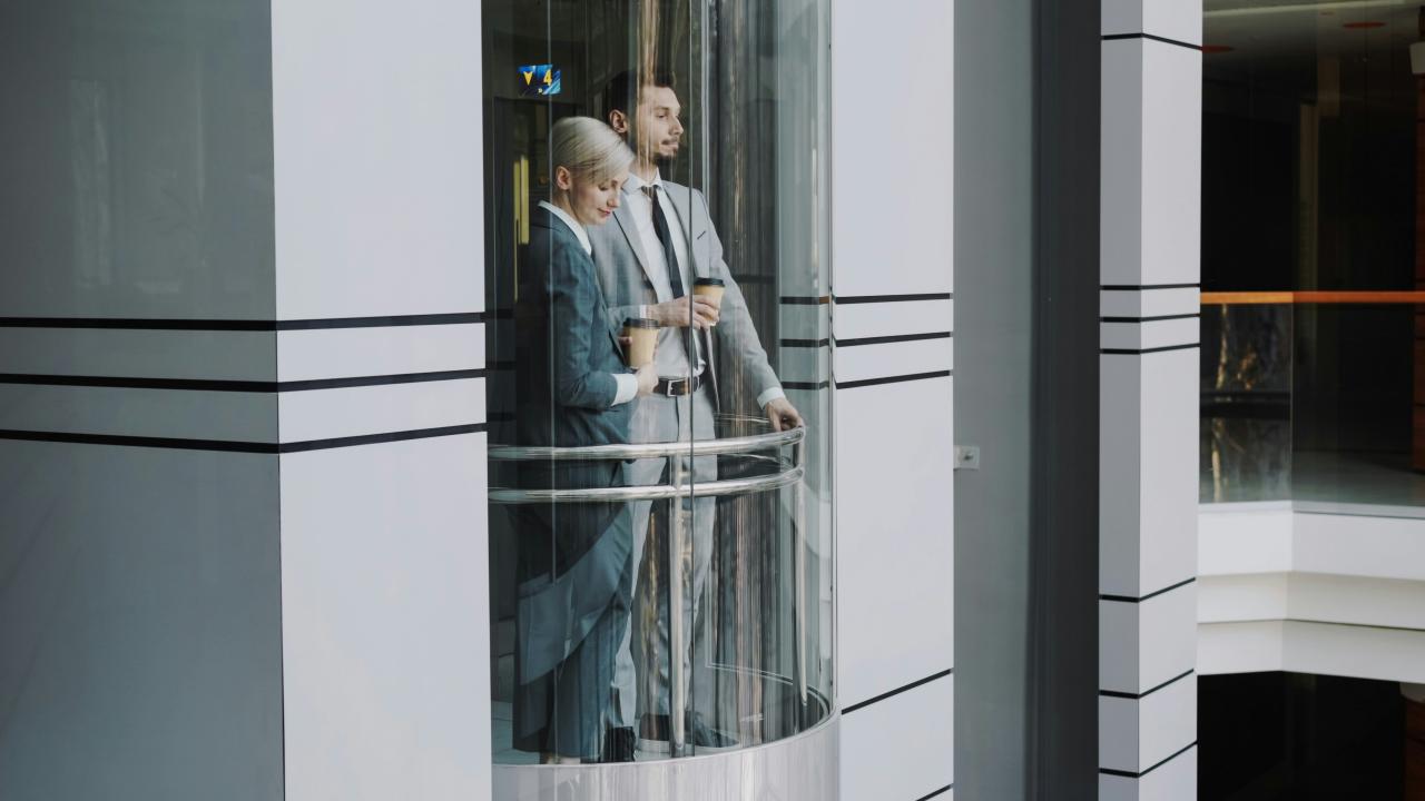 Dua pebisnis di lift kaca